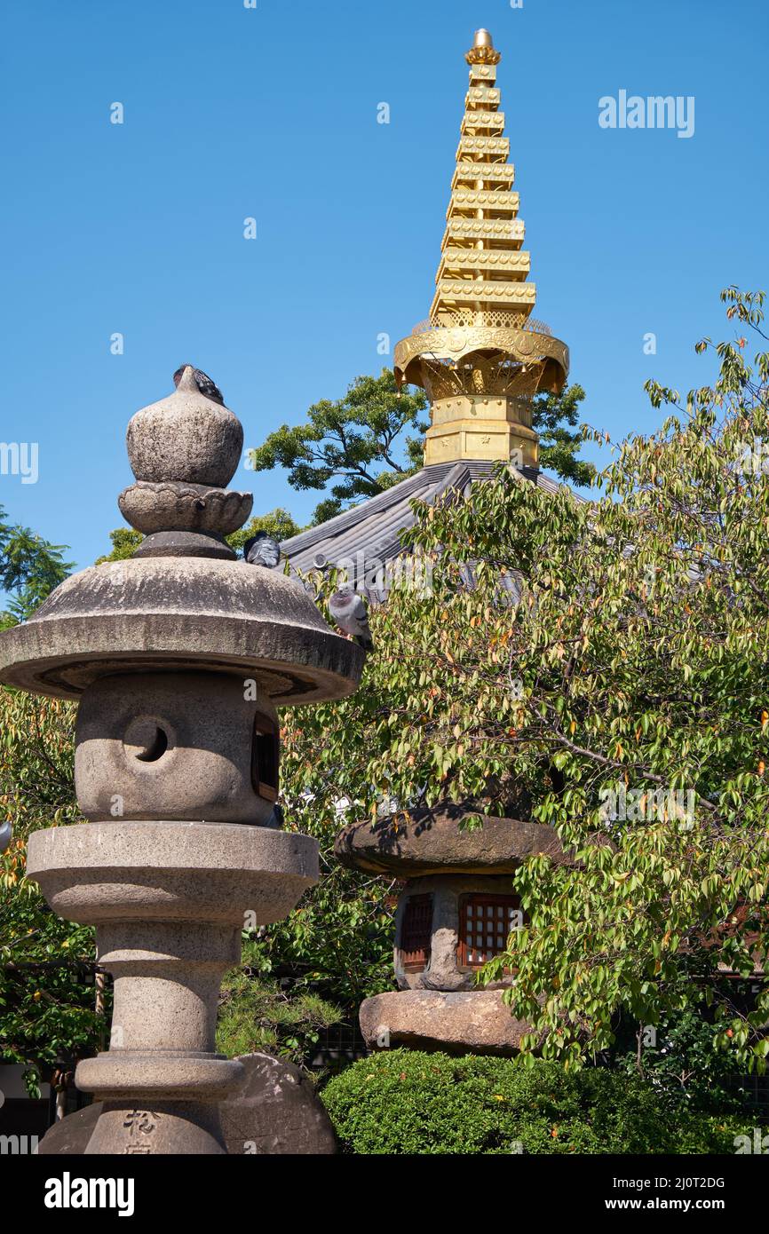 Lanternes traditionnelles en pierre avec pagode sorin sur le fond dans le jardin du temple. Osaka. Japon Banque D'Images