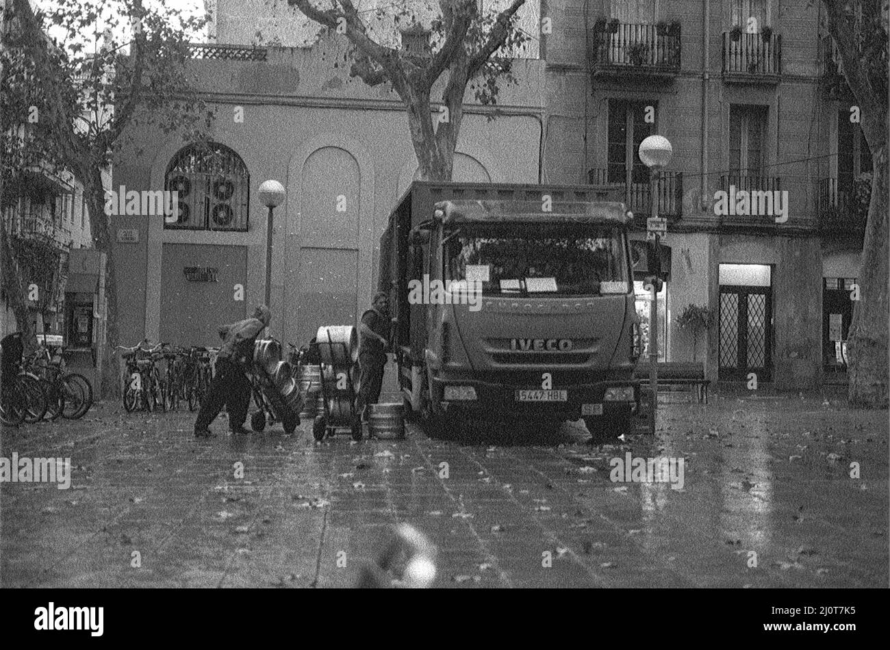 Photo en niveaux de gris d'un gros camion Iveco Eurocargo livrant dans la ville. Barcelone, Espagne Banque D'Images