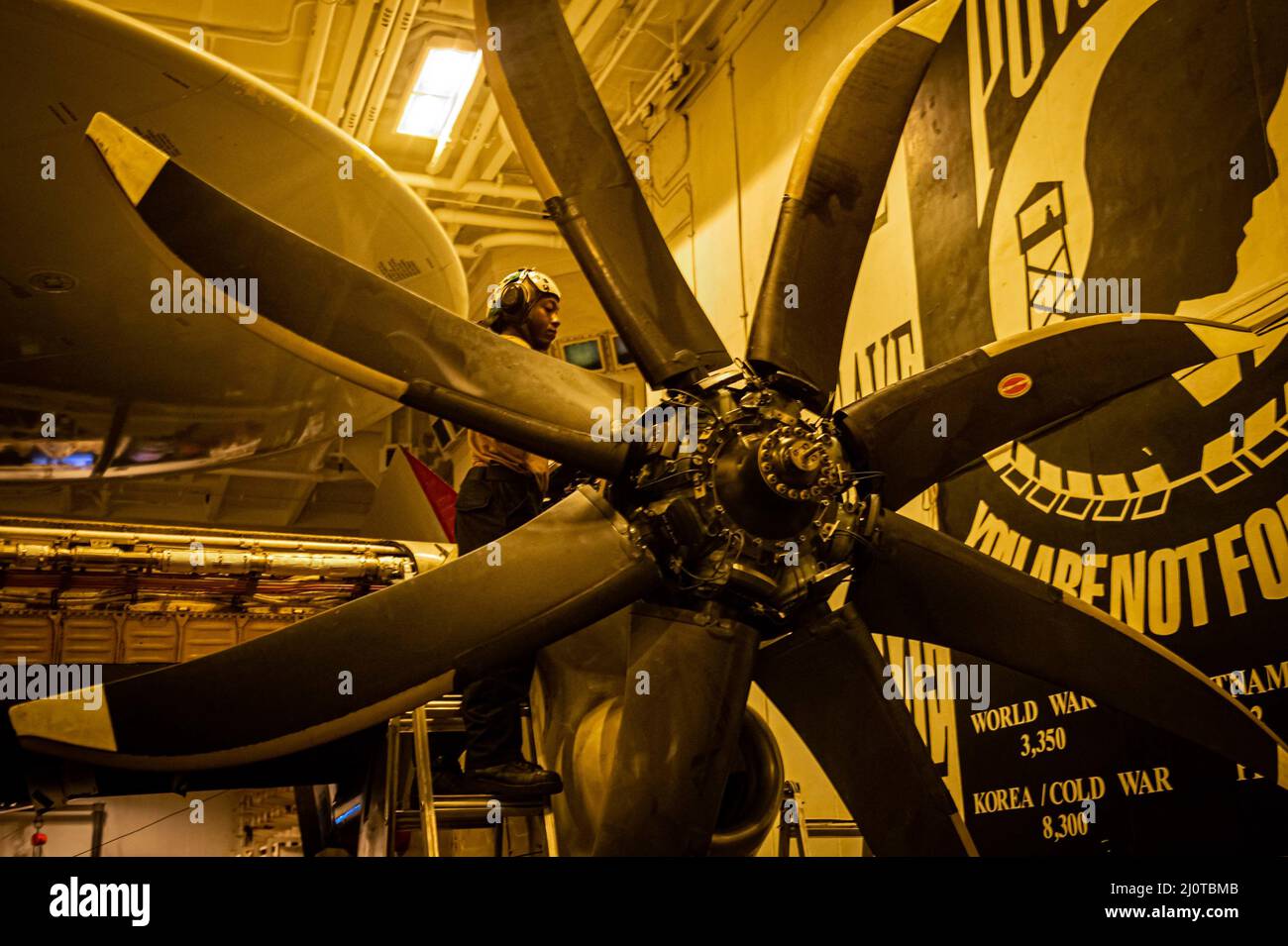 220122-N-TD381-1212 MER DES PHILIPPINES (JANV 22, 2022) Aviation Machinist’s Mate 3rd Class Jason Timmons, originaire de Chicago, Illinois, effectue la maintenance d’un E-2D Advanced Hawkeye, affecté aux «Black Eagles» du Carrier Airborne Early Warning Squadron (VAW) 113, dans la baie hangar du porte-avions USS Carl Vinson (CVN 70) de la classe Nimitz, le 22 janvier 2022. Carl Vinson Carrier Strike Group est en cours de déploiement prévu dans la zone d'exploitation de la flotte américaine 7th afin d'améliorer l'interopérabilité par le biais d'alliances et de partenariats tout en servant de force de réponse prête à l'emploi pour soutenir un Indo libre et ouvert Banque D'Images