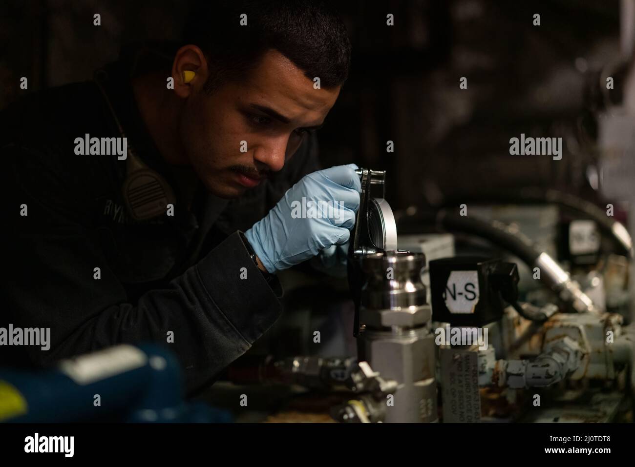 220124-N-FA490-1185 MANILLE, Philippines (janv 24, 2022) Engineman Fireman Carlos Reynaga-Nunez, de Davenport, en Floride, affecté au navire de combat littoral version Independence USS Jackson (LCS 6) sonne un réservoir d'huile de lubrification dans un espace d'ingénierie à bord de Jackson. Attaché au destroyer Squadron (DESRON) 7, Jackson est en cours de déploiement par rotation dans la zone d'opérations de la flotte américaine 7th afin de soutenir la sécurité et la stabilité dans la région, Et de travailler aux côtés des marines alliées et partenaires pour assurer la sécurité et la stabilité maritimes, les piliers essentiels d'une Indo-Pacifique libre et ouverte. (É.-U. Photo de la marine par Mass Co Banque D'Images