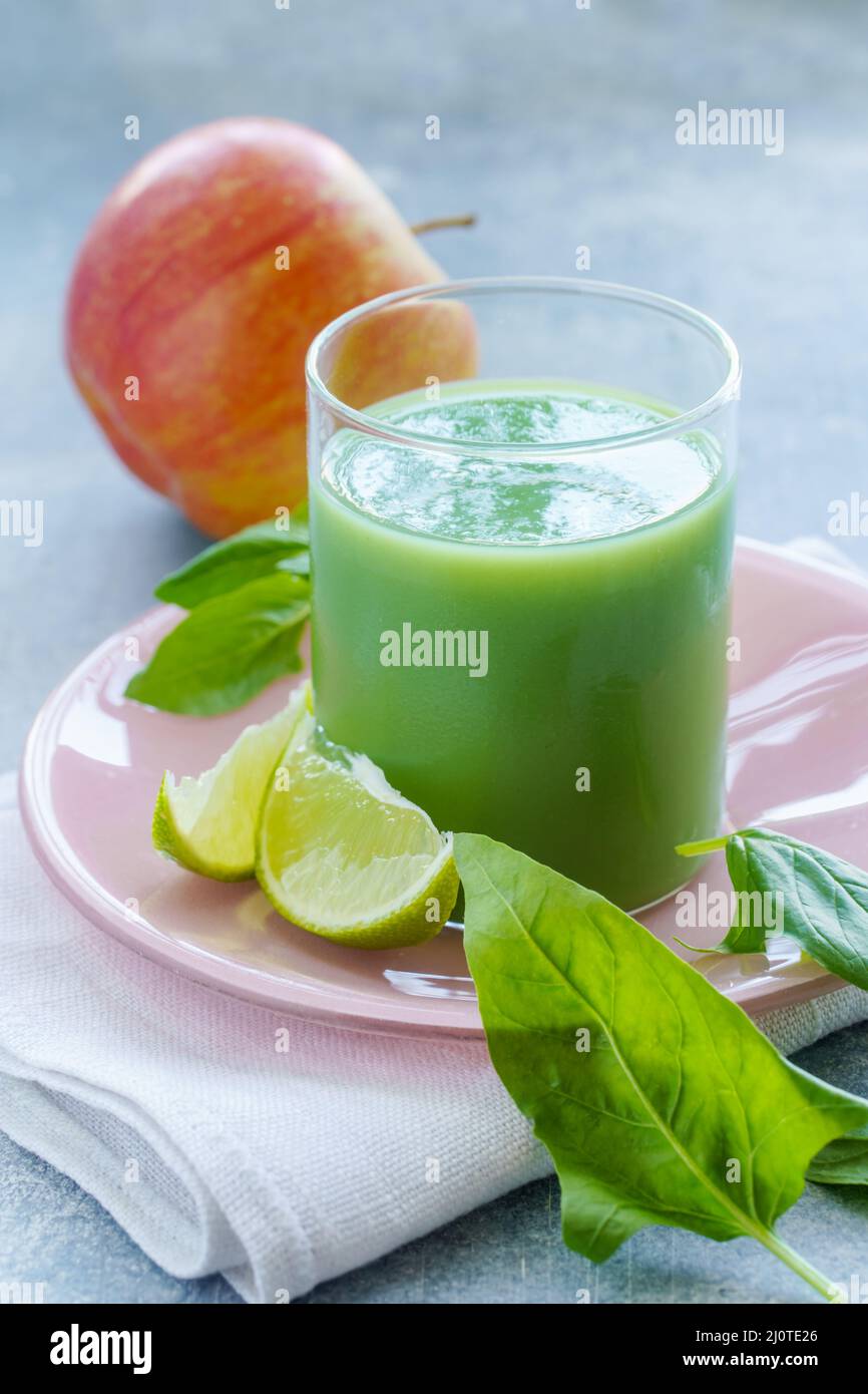 Smoothie vert avec feuilles d'épinards, jus de lime et pomme dans un verre, gros plan Banque D'Images