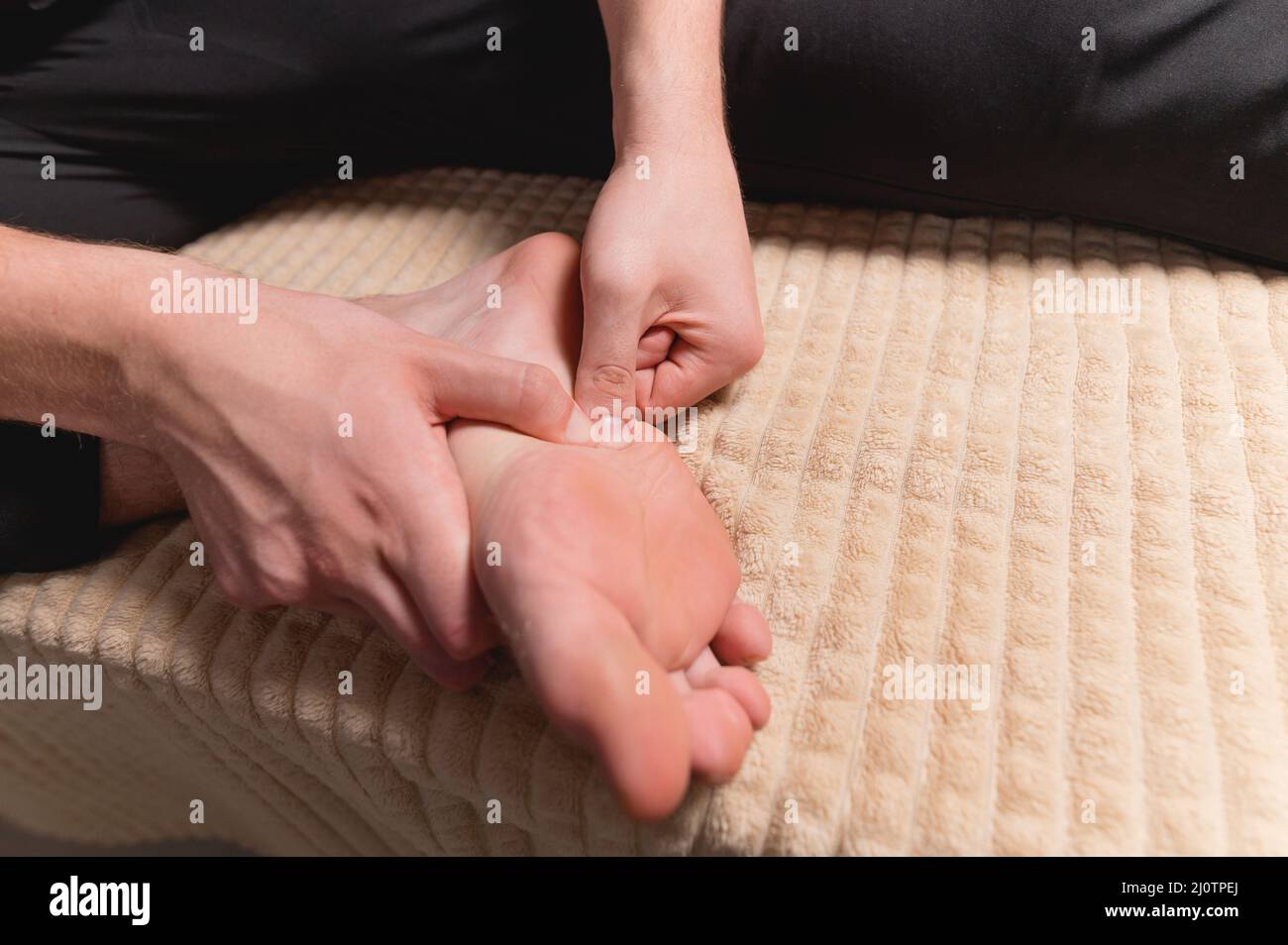 Homme caucasien faisant l'auto-massage du pied et de la surface de la jambe. Prévention des pieds plats et soin de votre corps Banque D'Images