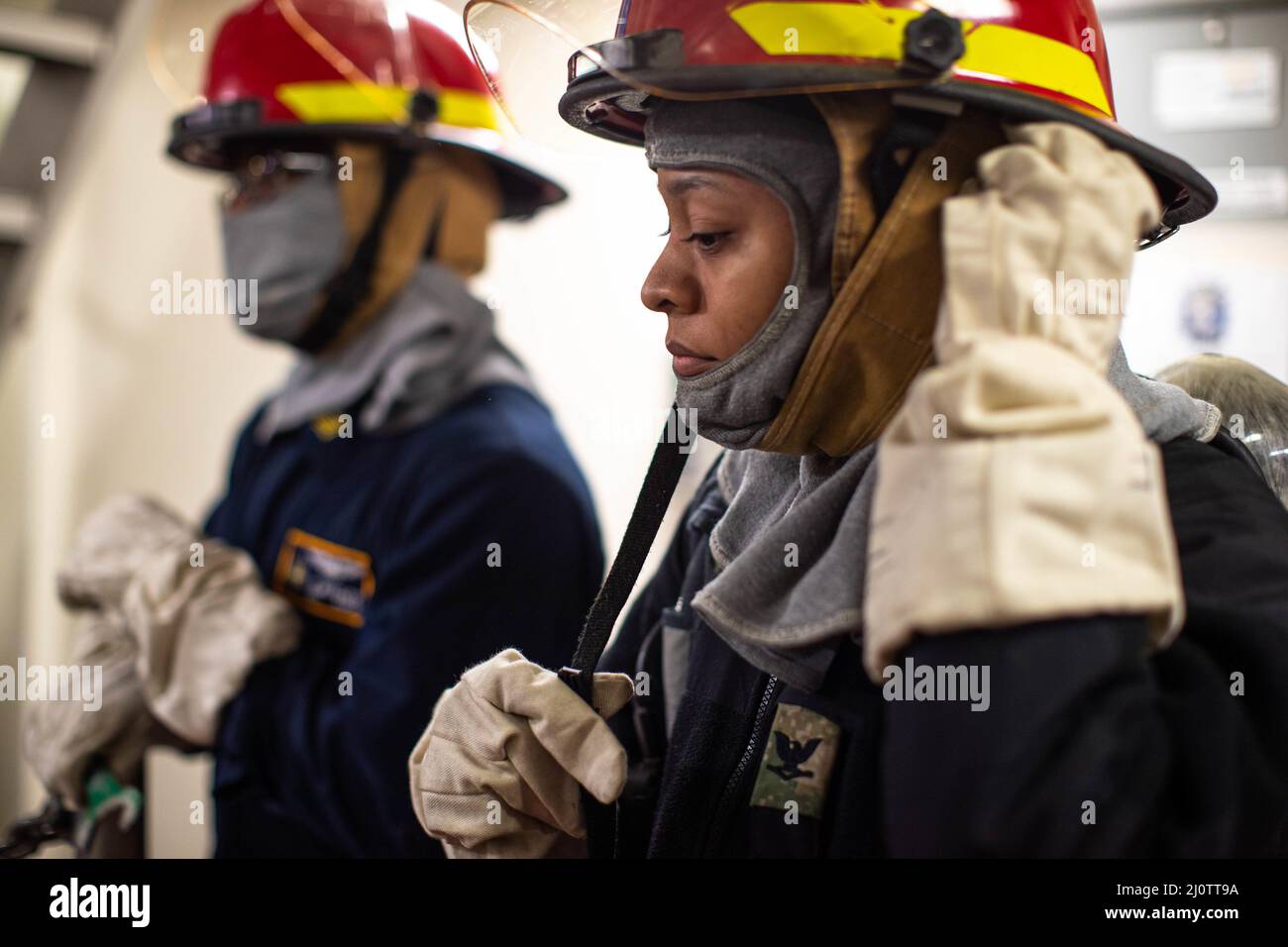 Technicien d'équipement de soutien à l'aviation 3rd classe Jazamyn Redday, de Bakersfield, Californie, affecté au service d'entretien intermédiaire de l'avion USS Gerald R. Ford (CVN 78), met sur son casque de lutte contre les incendies alors qu'elle se prépare à combattre la rupture de conduite lors d'une évaluation de certification d'équipage de phase III, le 27 janvier 2022. La phase III de la certification des équipages porte sur la façon dont les équipes de formation du navire suivent la formation nécessaire pour retourner le navire en mer. Ford est dans le port de Newport News Shipyard exécutant sa disponibilité incrémentale prévue (PIA), une période de six mois de modernisation, m Banque D'Images