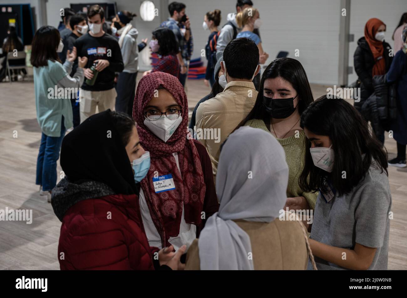 Des invités afghans parlent avec des étudiants de l'université de Princeton en visite à la base conjointe McGuire-dix-Lakehurst, New Jersey, le 28 janvier 2022. Le ministère de la Défense, par l'intermédiaire du Commandement du Nord des États-Unis, et en appui au ministère de la sécurité intérieure, fournit le transport, le logement temporaire, le dépistage médical et le soutien général à au moins 11 000 évacués afghans à Liberty Village, dans des structures permanentes ou temporaires, le plus rapidement possible. Cette initiative fournit un soutien essentiel au personnel afghan dans des lieux sécurisés à l'extérieur de l'Afghanistan. (É.-U. Photo de la Force aérienne par Tech. Sgt. Matthew B. Freder Banque D'Images