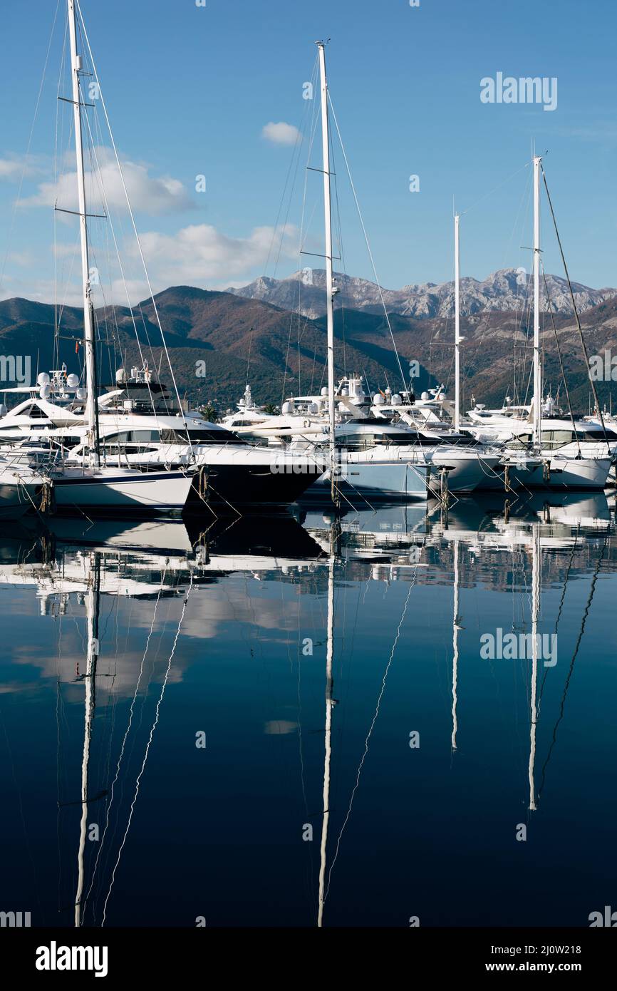 Les yachts à voile sont amarrés sur la jetée avec les montagnes en arrière-plan.Porto, Monténégro Banque D'Images