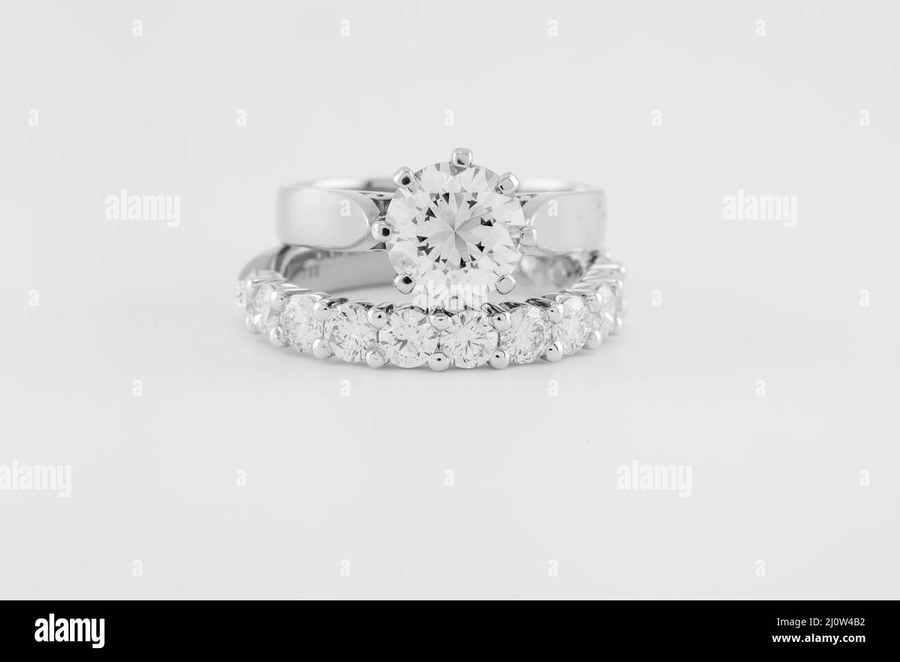 Un anneau d'engagement de diamant de deux carats solitaire sur un cercle de diamants anneau de mariage, image monotone. Banque D'Images