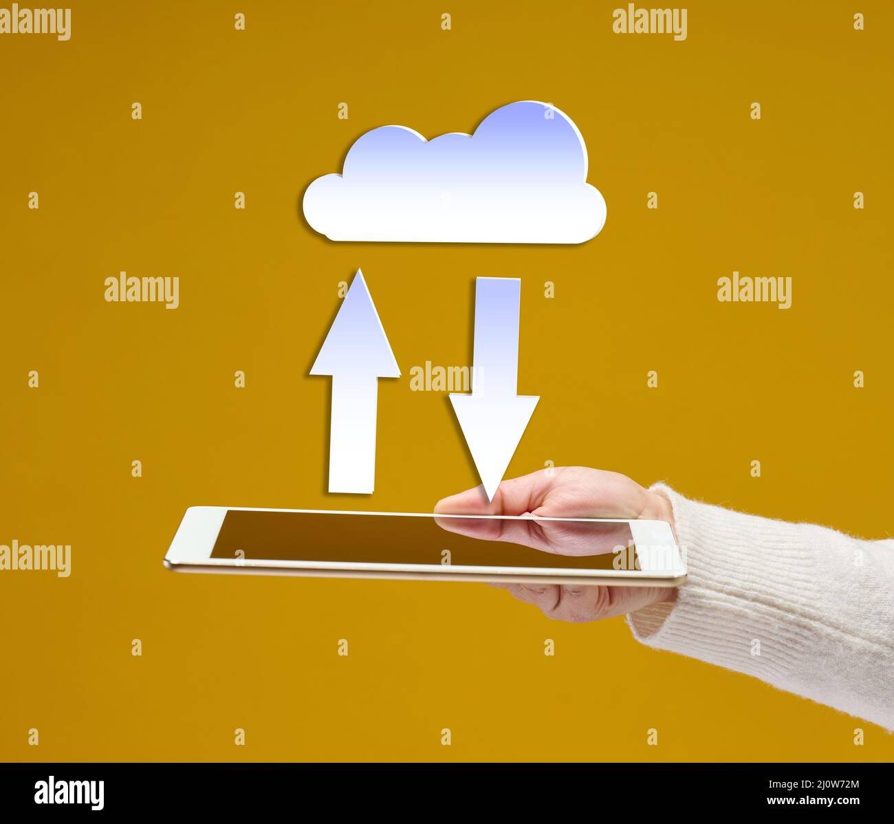 La main femelle tient une tablette de gadget électronique sur un fond jaune, un nuage blanc avec des flèches au-dessus. Échange d'informations, da Banque D'Images