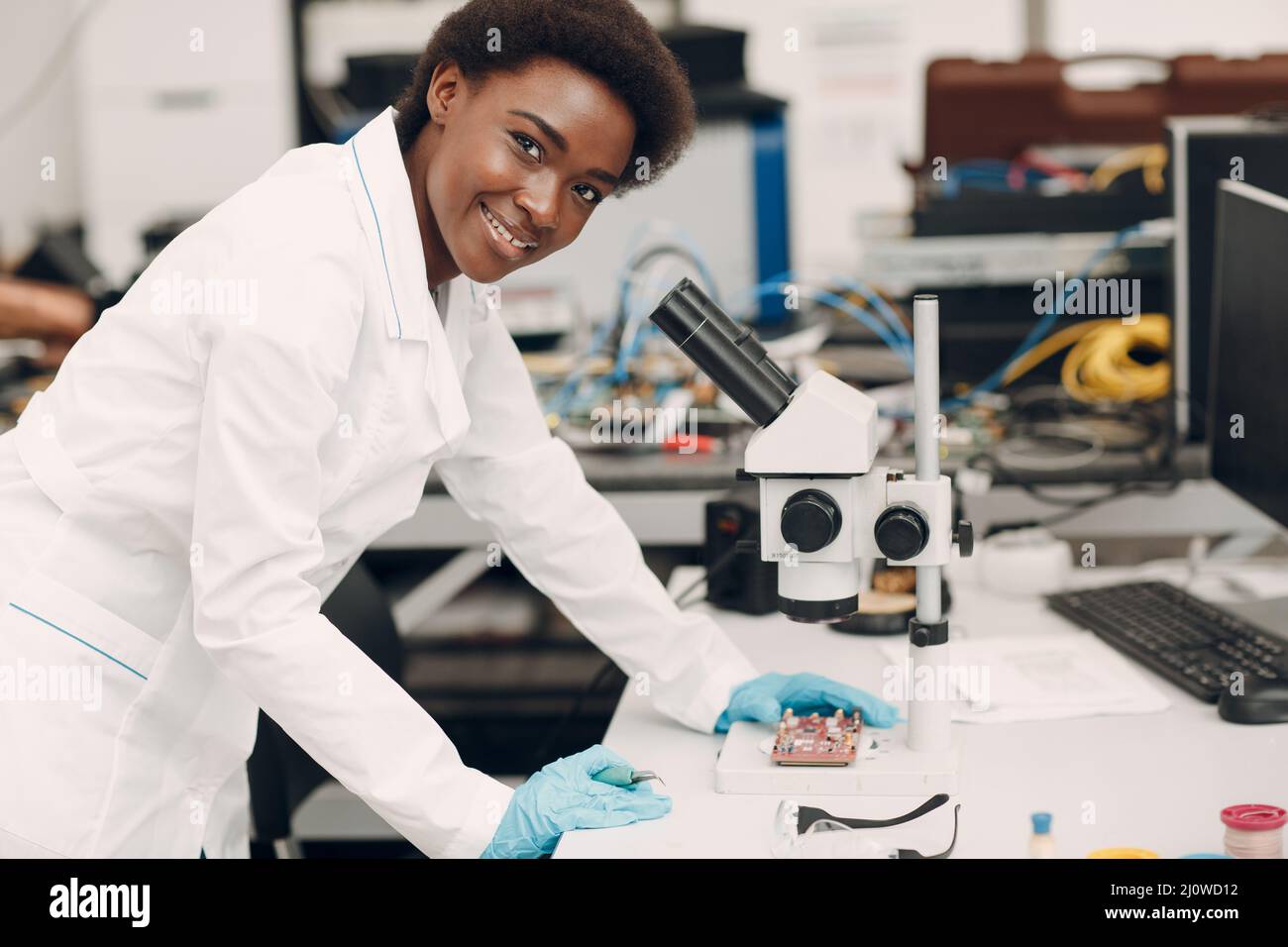Scientifique afro-américaine femme travaillant en laboratoire avec des instruments électroniques Banque D'Images