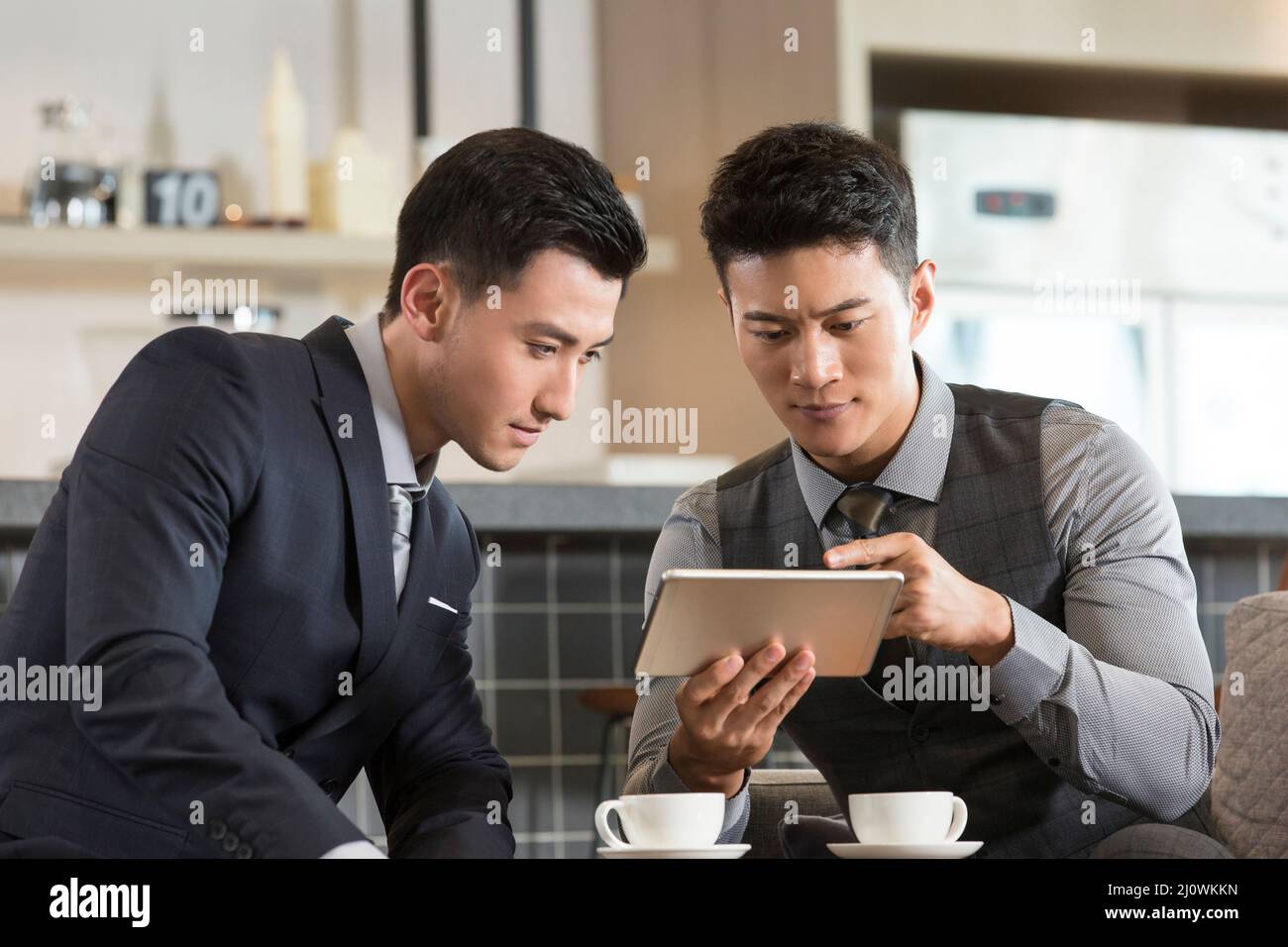 Les hommes d'affaires chinois travaillent et boivent du café Banque D'Images