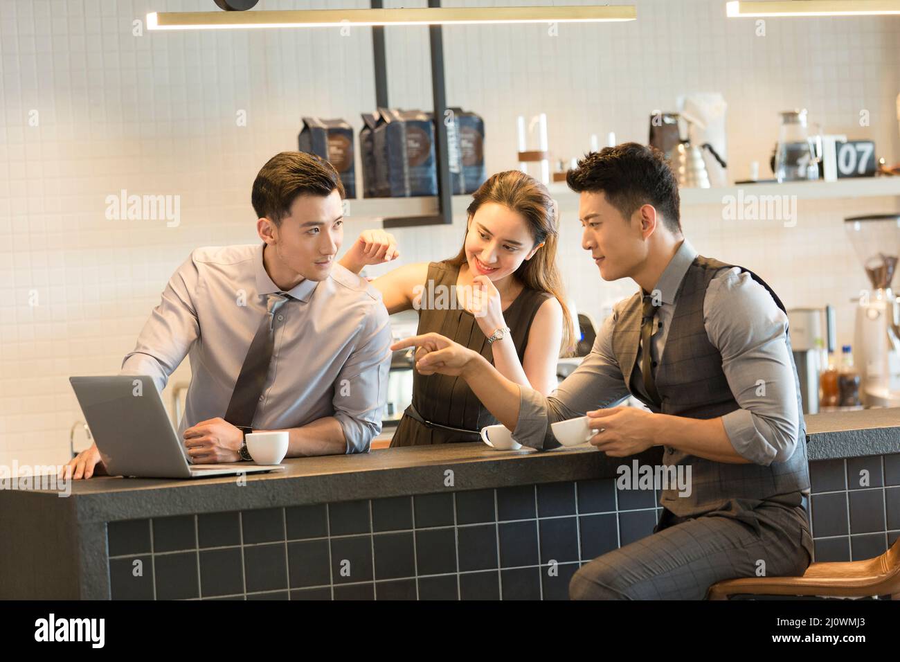 Des collègues chinois travaillant avec un ordinateur portable dans des cafés Banque D'Images