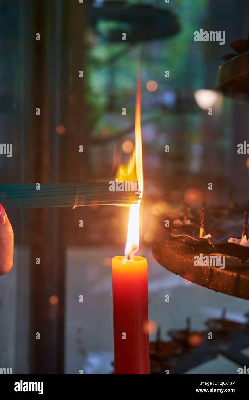 Un bouquet de bâtons d'arôme sont illuminés à partir d'une bougie qui brûle dans un chandelier dans un temple japonais. Japon Banque D'Images