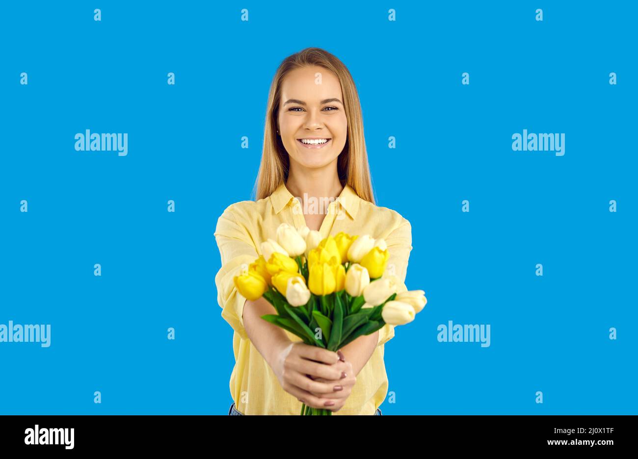 Studio portrait de la jeune femme heureuse tenant un bouquet de magnifiques tulipes jaunes et blanches Banque D'Images
