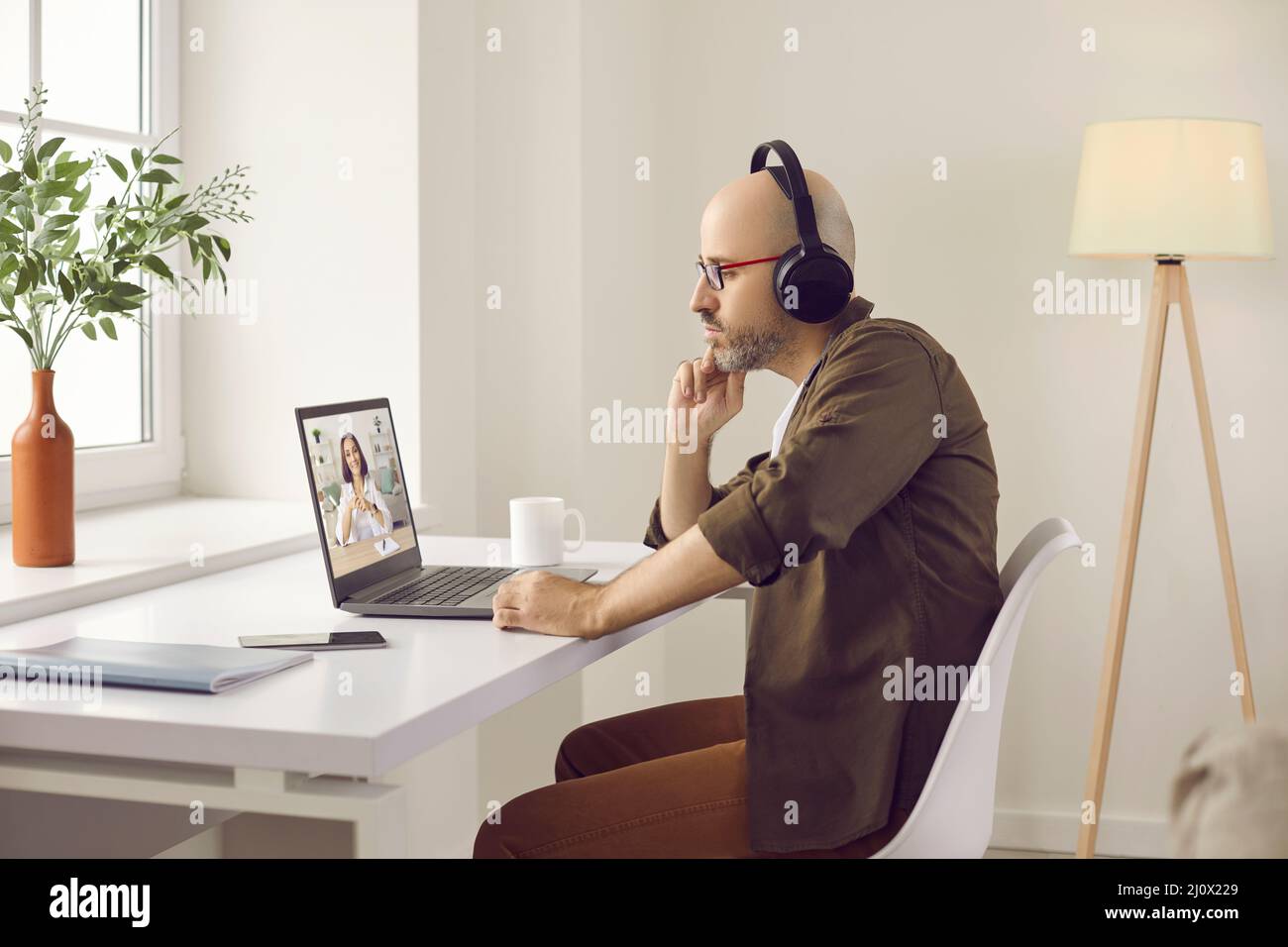 Homme attentif qui regarde des formations professionnelles, des webinaires en ligne ou qui parle lors d'un appel vidéo. Banque D'Images