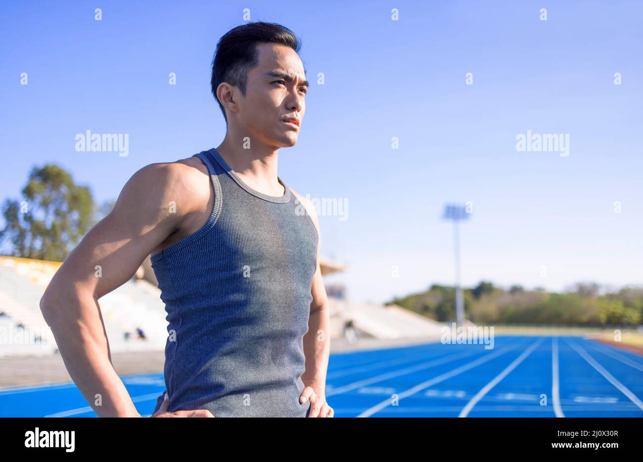 Beau sportif asiatique avec corps musclé sur le stade Banque D'Images