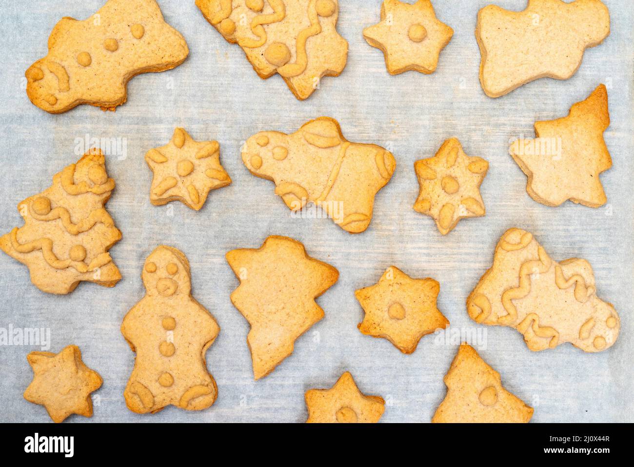 Gingerbread Cookies de Noël, pâte cuite au four. Sur du papier sulfurisé. Le concept de repas de Noël. Banque D'Images