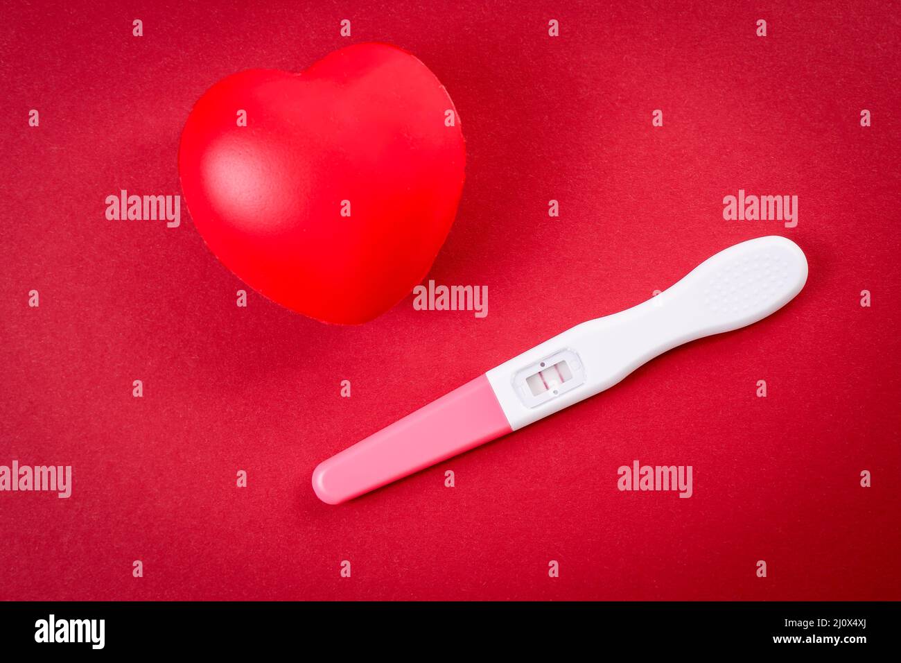 Test de grossesse positif et cœur en caoutchouc rouge Photo Stock - Alamy