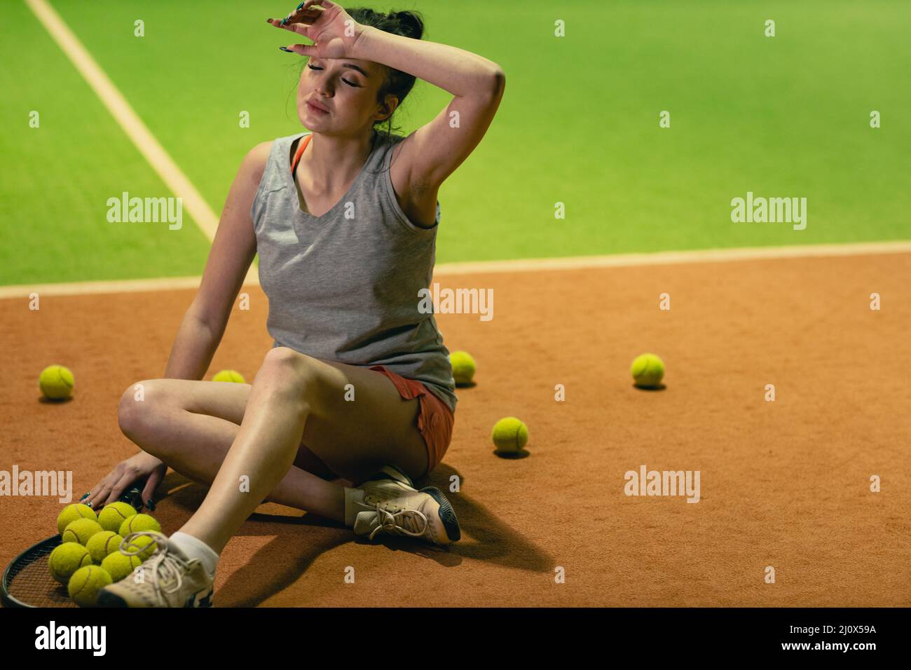 Une joueuse de tennis s'entraîne avec une raquette et un ballon sur le court Banque D'Images