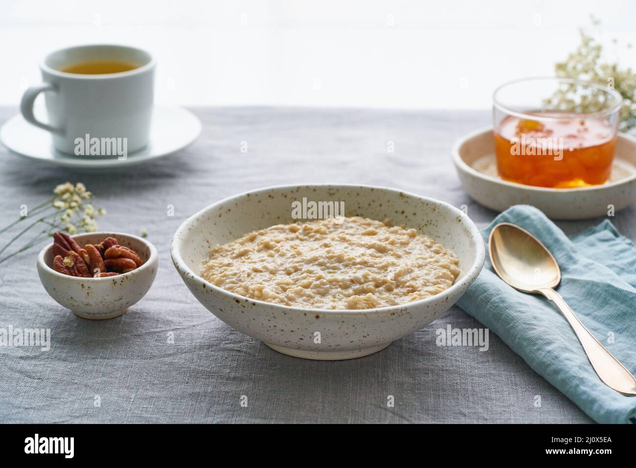 Flocons d'avoine entiers, grand bol de porridge avec beurre pour le petit déjeuner, repas du matin. Vue latérale Banque D'Images