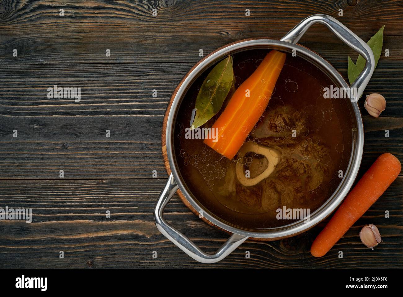 Bouillon de viande de bœuf, l'ossobuco sur l'os, soupe riche dans une casserole, longue cuisson lente. Banque D'Images Bouillon de viande de bœuf, l'ossobuco sur l'os, soupe riche dans une casserole, longue cuisson lente. Banque D'Images