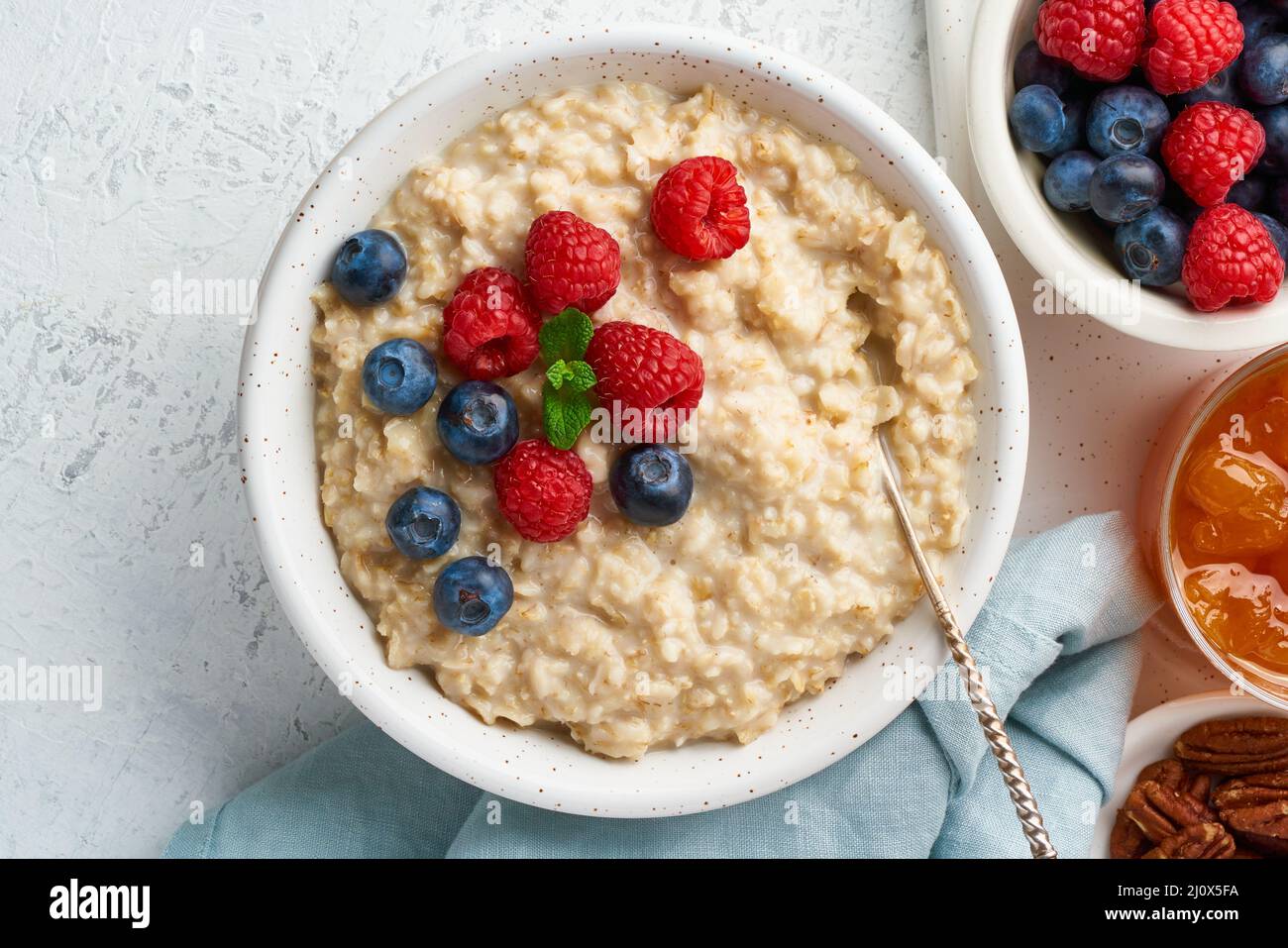 Porridge de flocons d'avoine avec myrtille, framboises, confiture, vue de dessus, gros plan. Petit déjeuner avec baies Banque D'Images