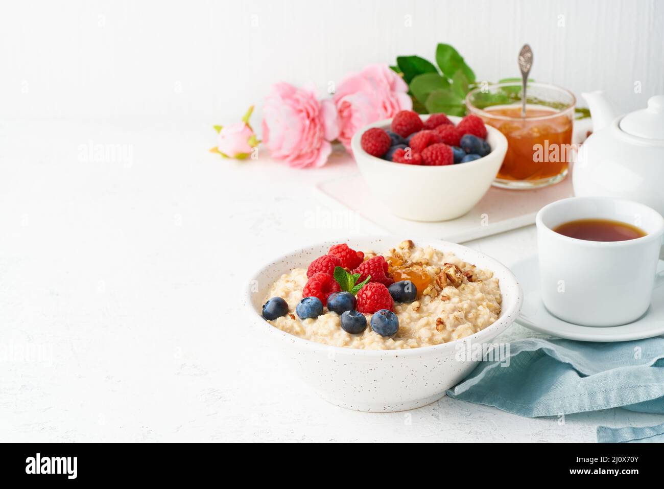 Porridge de flocons d'avoine avec bleuets, framboises, confiture et noix, vue latérale, espace de copie, Banque D'Images