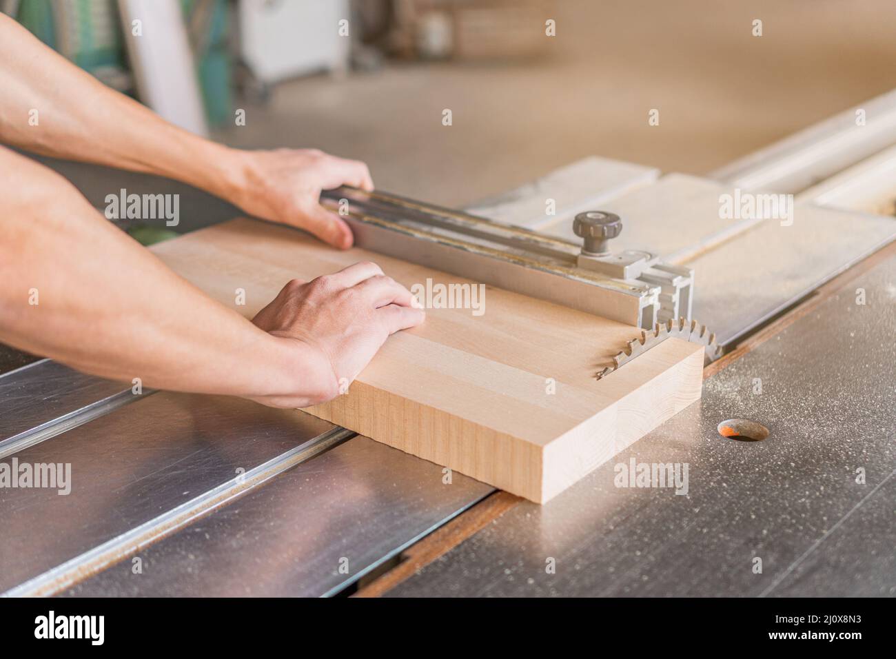 Charpentier non reconnaissable sciant une planche en bois dans un atelier Banque D'Images