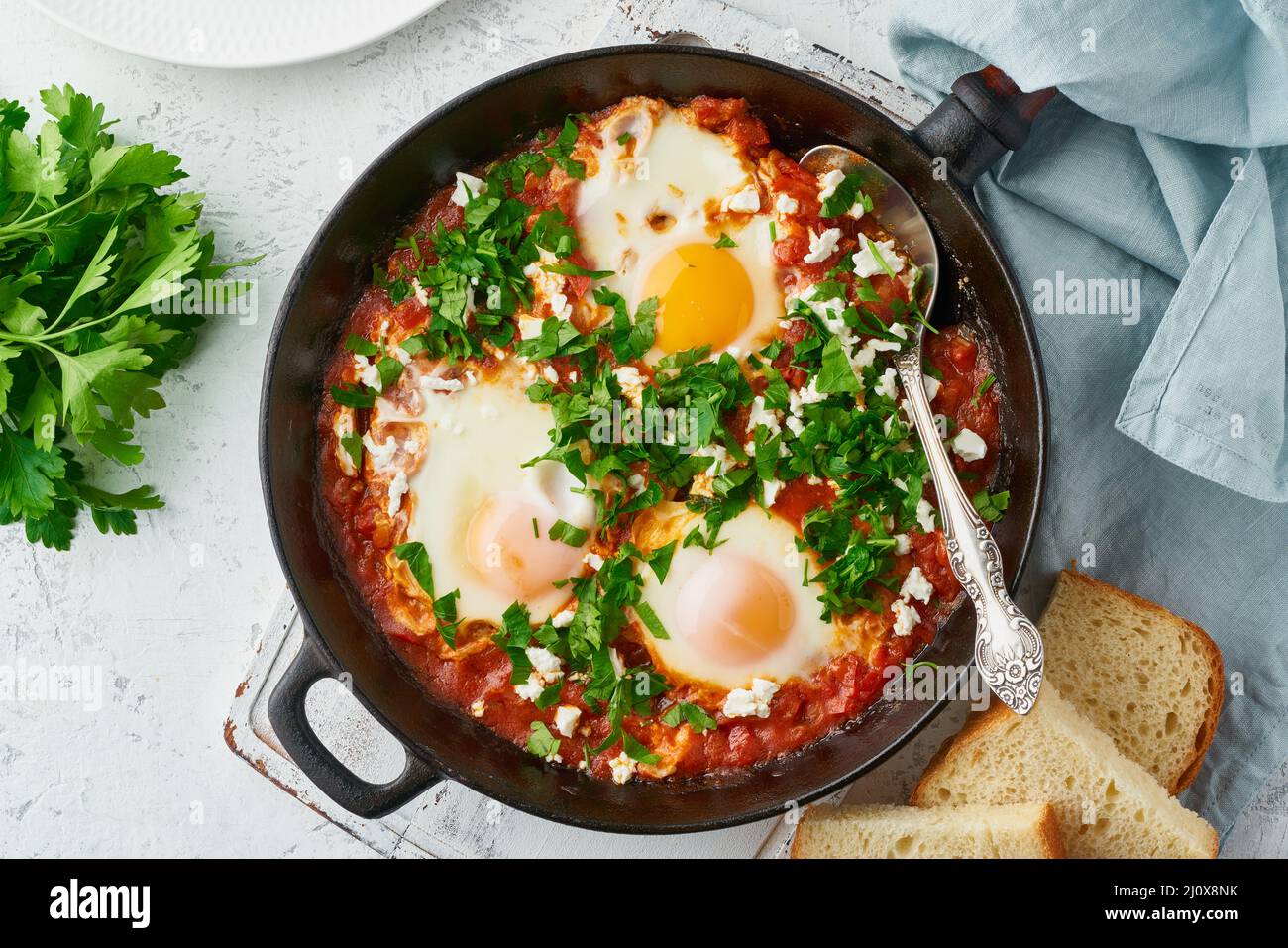 Shakshouka, œufs pochés dans une sauce aux tomates, huile d'olive. Cuisine méditerranéenne. Banque D'Images