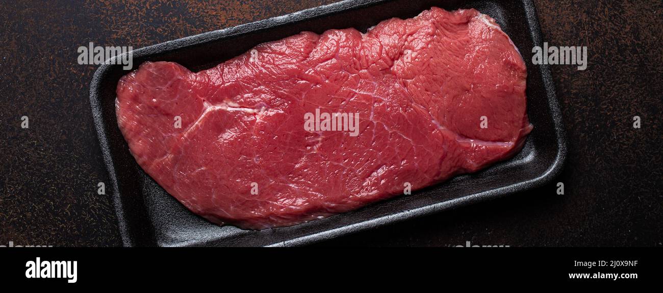 Steak de filet cru maigre de bœuf dans un contenant en plastique noir Banque D'Images