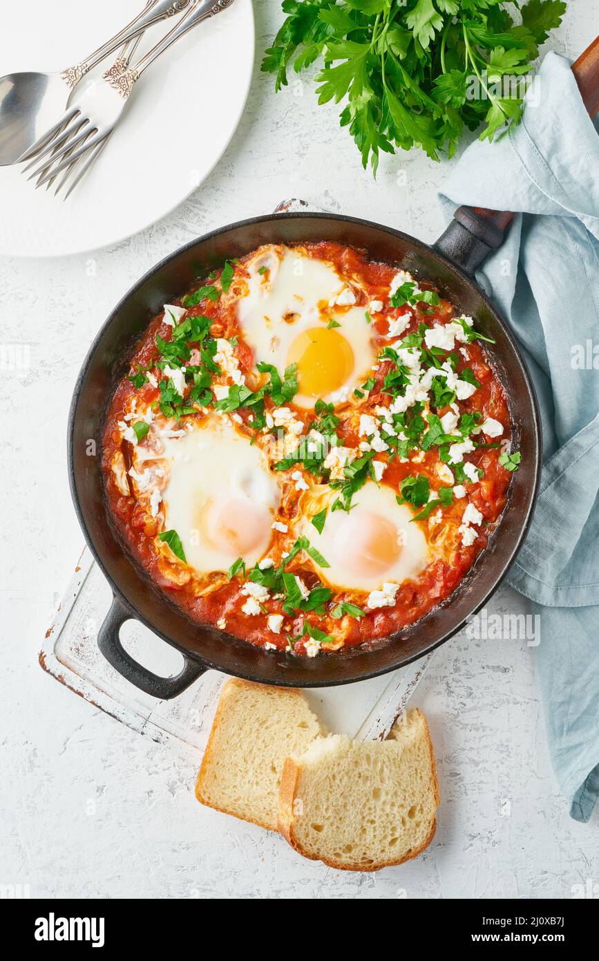 Shakshouka, œufs pochés dans une sauce aux tomates, huile d'olive. Cousine méditerranéenne. Banque D'Images