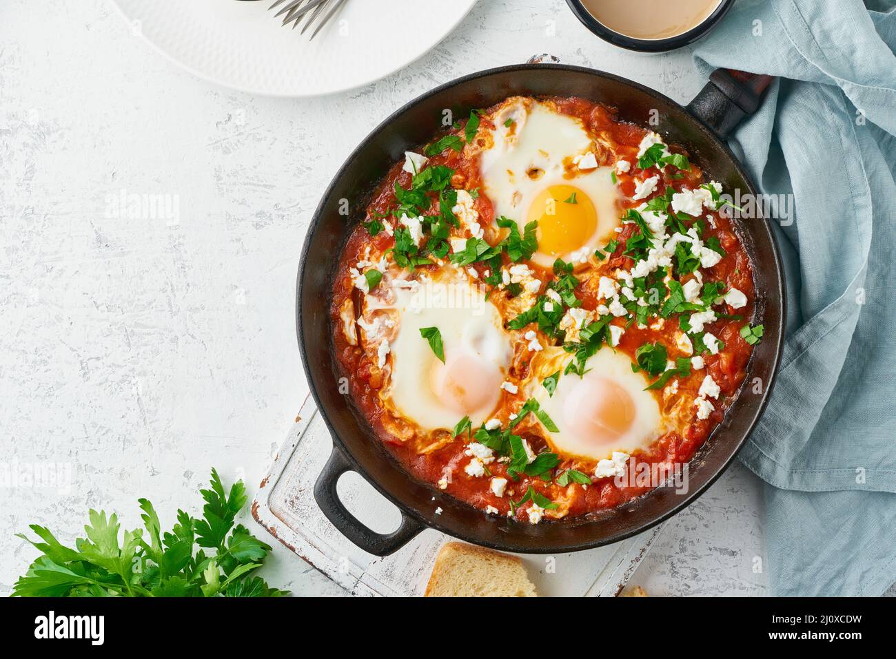 Shakshouka, œufs pochés dans une sauce aux tomates, huile d'olive. Cousine méditerranéenne. Banque D'Images