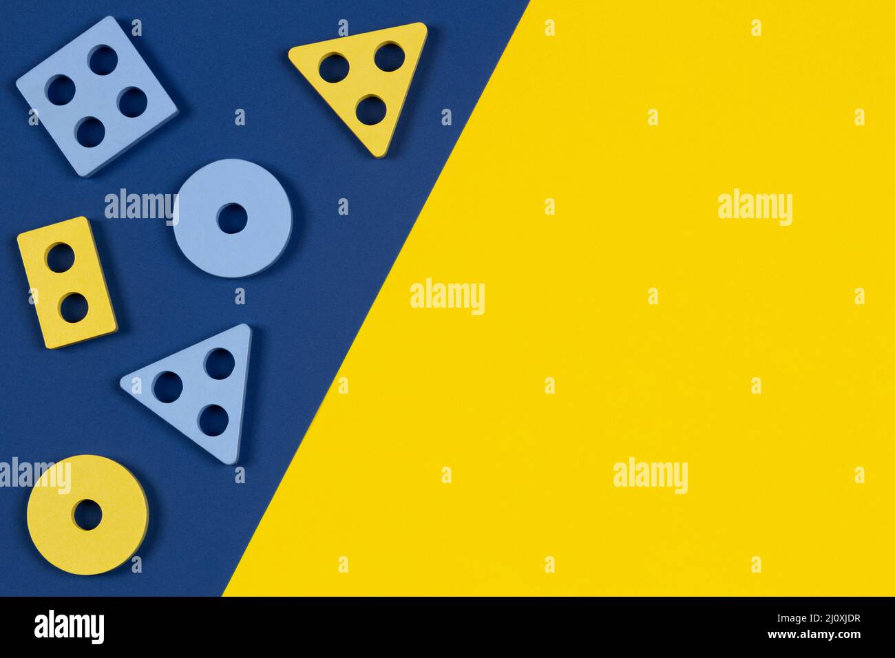 Vue de dessus sur les blocs de bois de la forme trieur pièces jouet sur fond jaune et bleu de couleur. Jouets éducatifs en bois Montessori pour enfants. Petite enfance Banque D'Images