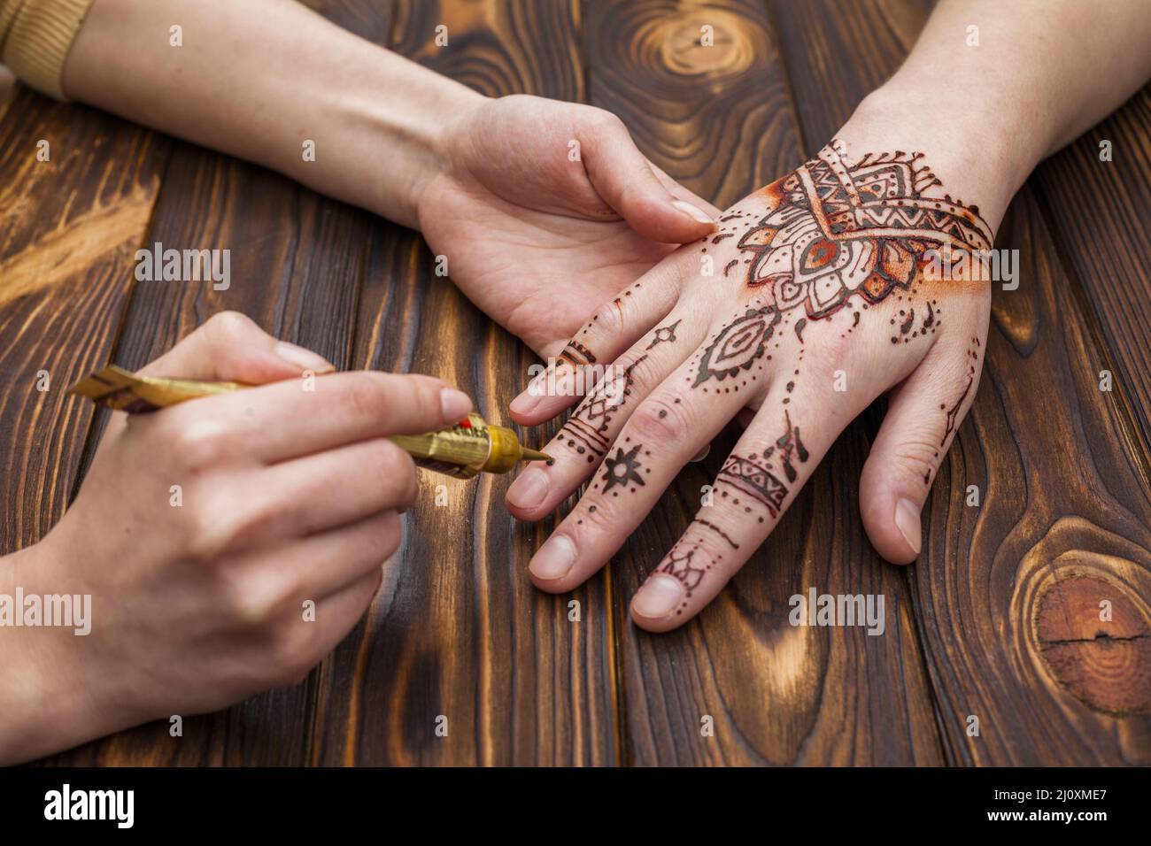 Artiste faisant main mehndi womans. Concept de photo de haute qualité Banque D'Images