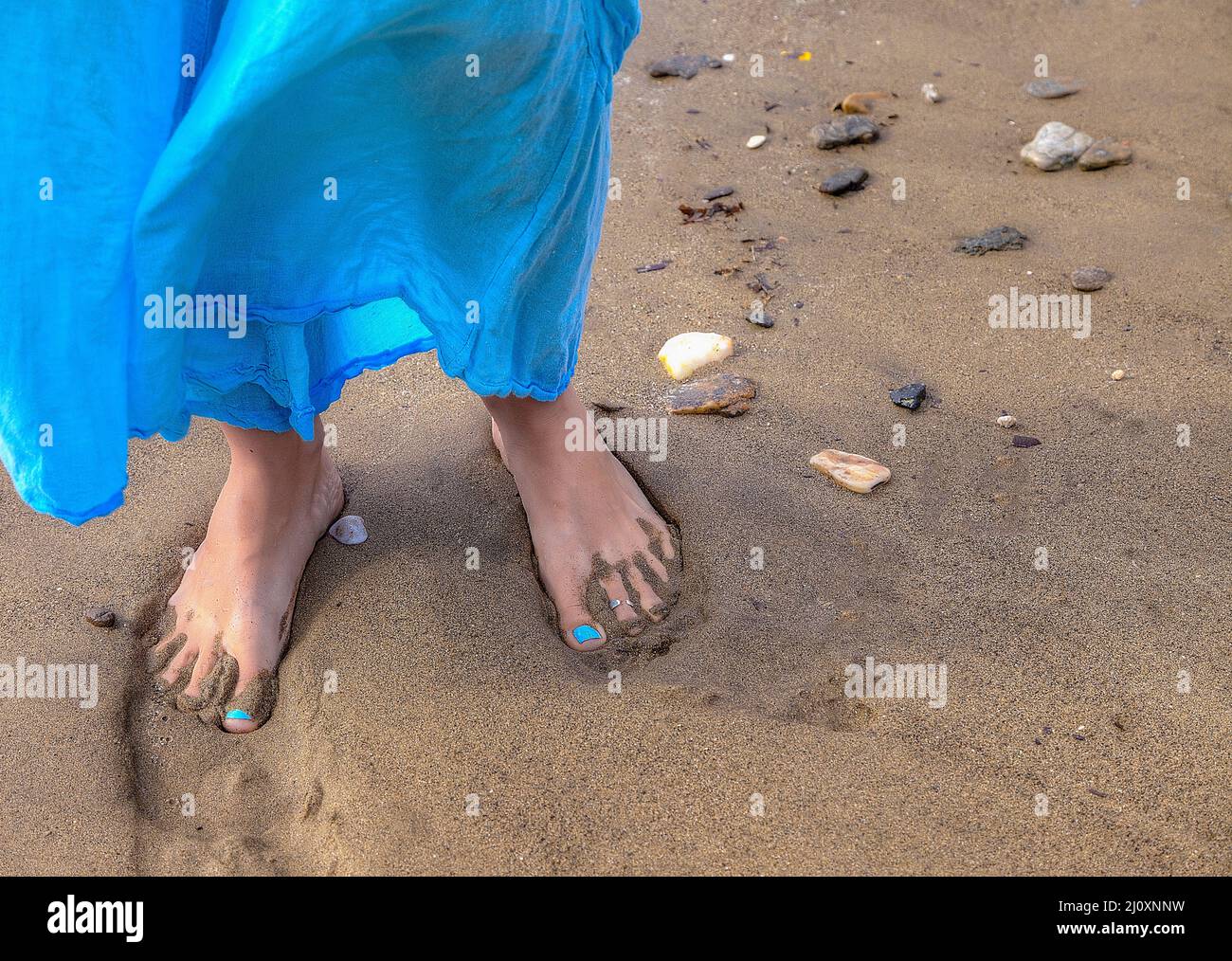 Jeune femme marchant pieds nus sur la plage. Image de stock. Banque D'Images