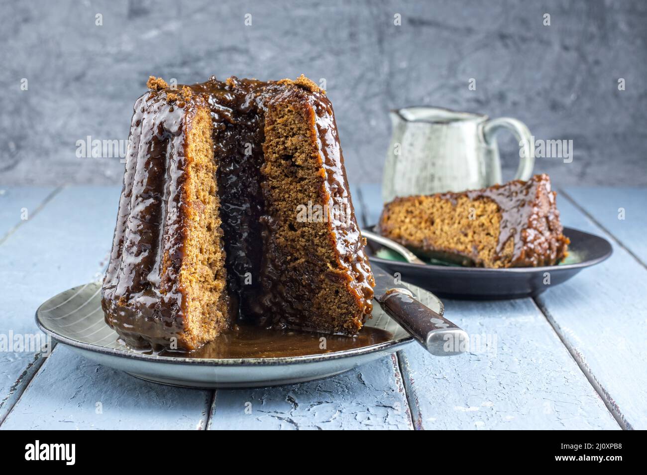 Pudding anglais traditionnel avec glaçage au caramel servi en gros plan sur une assiette design Banque D'Images