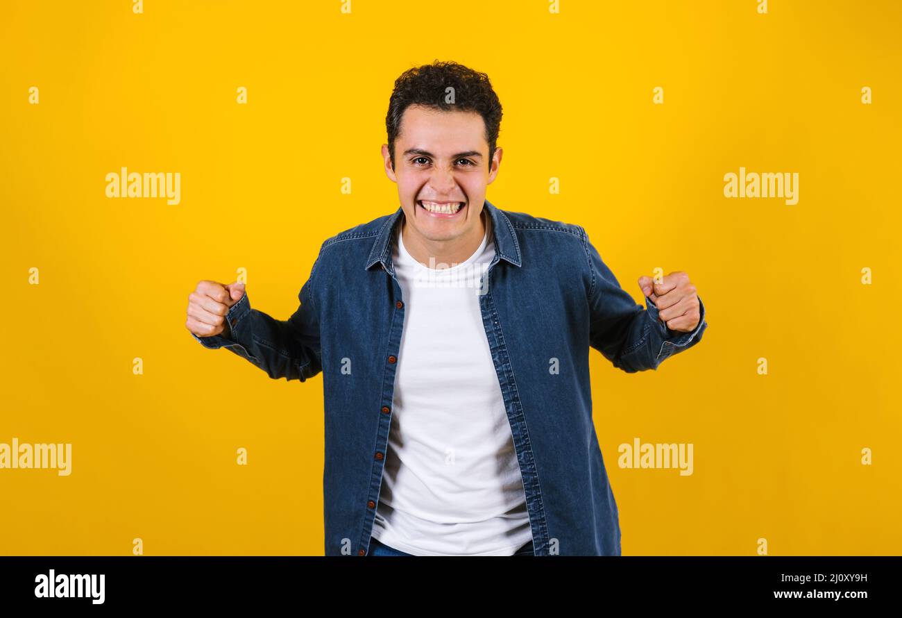 Portrait du jeune homme positif hispanique souriant sur fond jaune au Mexique en Amérique latine Banque D'Images