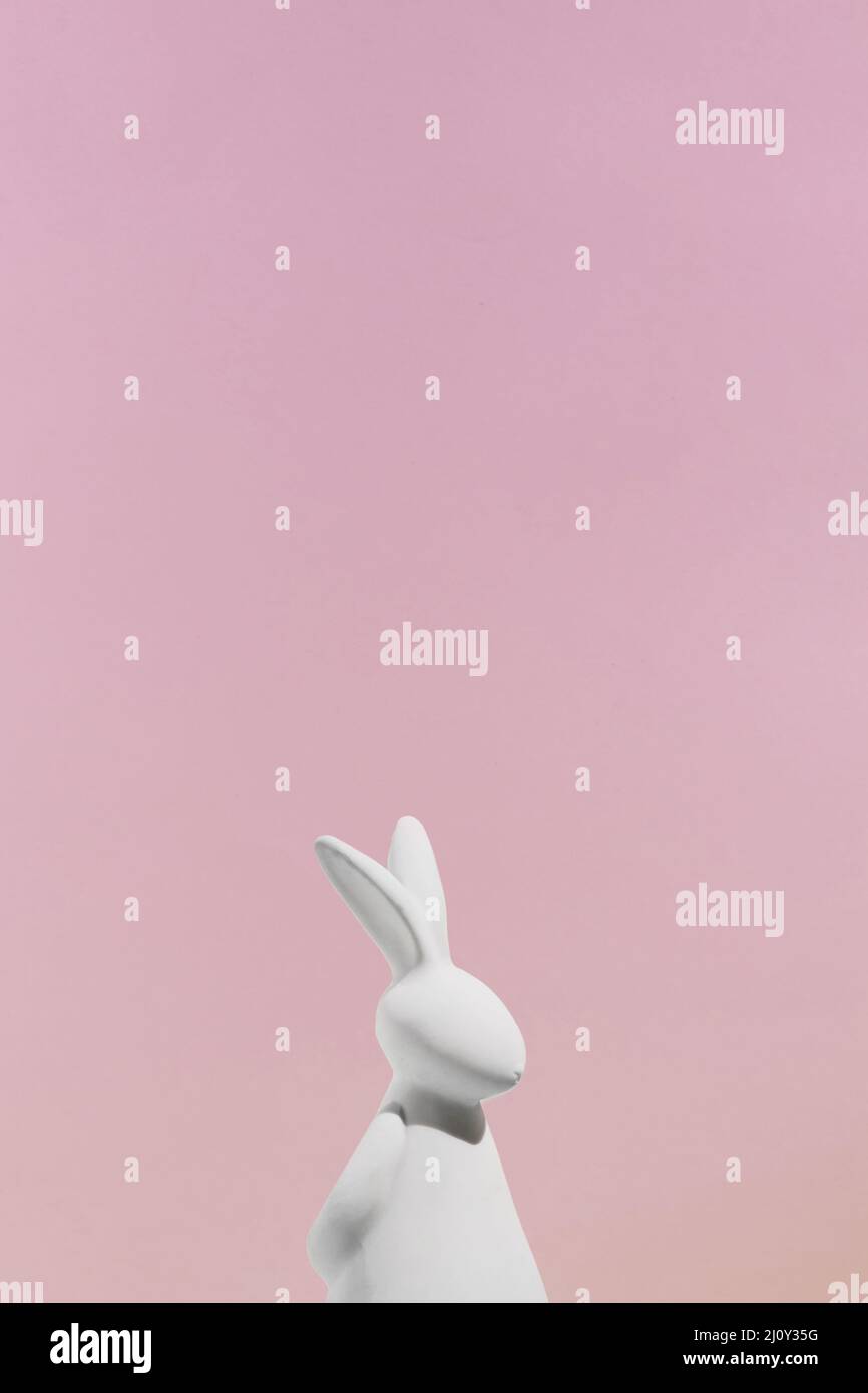 Figurine de lapin blanc sur fond rose. Photo de haute qualité Banque D'Images