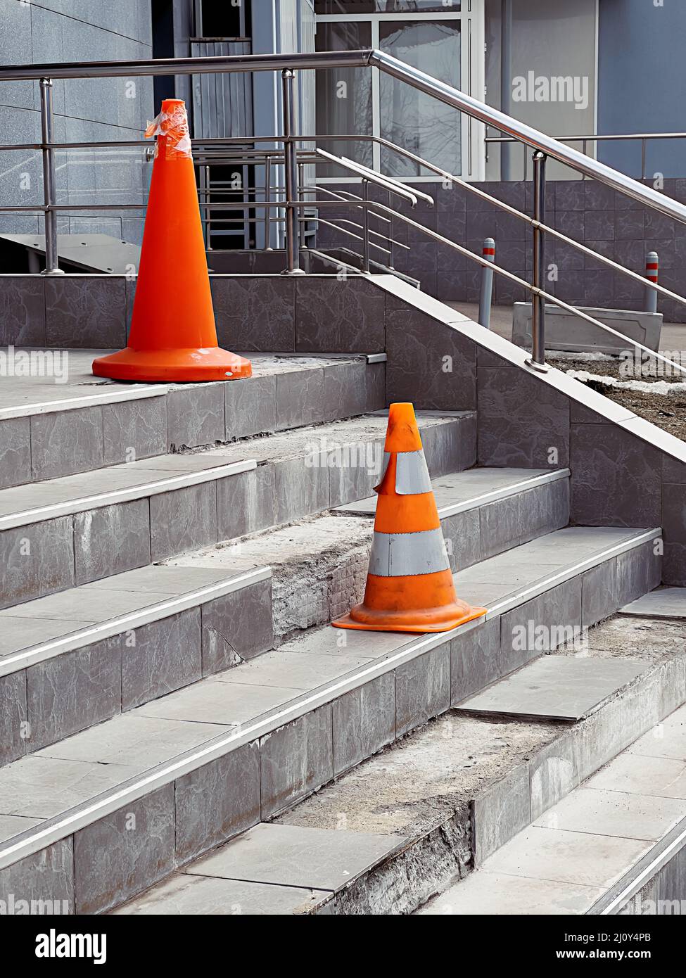 Les cônes de protection orange sur les marches cassées dans le bâtiment de bureau avertissent de danger. Banque D'Images