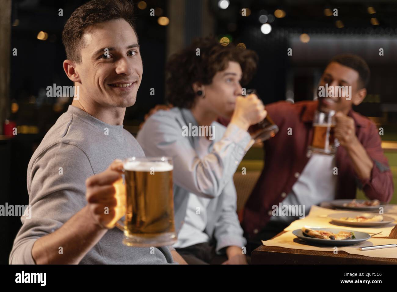 Les hommes en moyenne dose boivent de la bière. Photo de haute qualité Banque D'Images