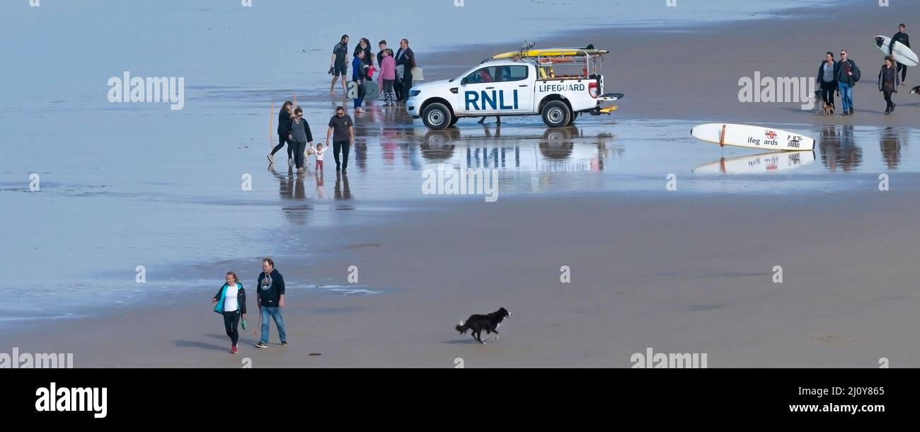 Une image panoramique d'un véhicule d'urgence RNLI et de vacanciers sur la plage de Fistral à Newquay en Cornouailles. Banque D'Images