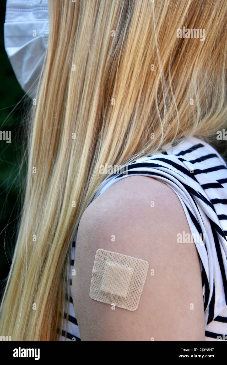 Photo d'une jeune femme blonde avec masque facial ayant pris le vaccin Covid ou corona Banque D'Images