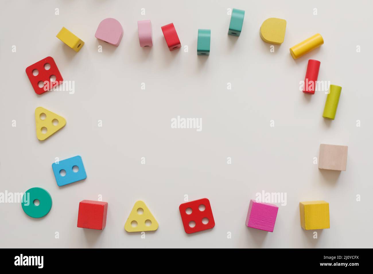 Vue de dessus coloré écologique non plastique jouets en bois sur table blanche. Apprentissage et développement précoces. Banque D'Images