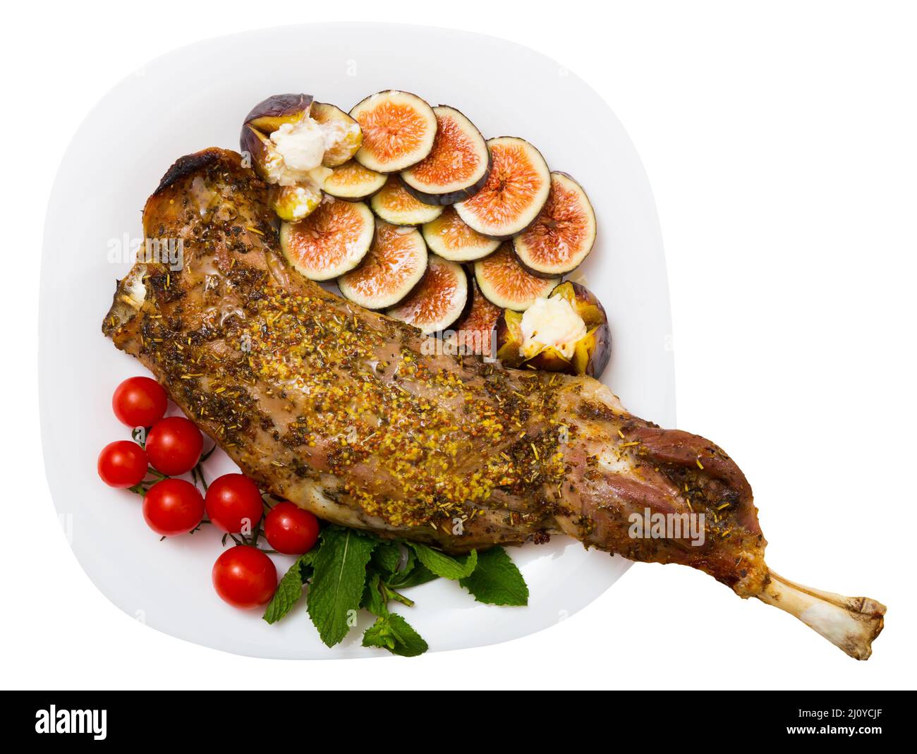 Savoureuse épaule d'agneau cuite au four avec du miel, servie avec des figues, du fromage feta et des herbes Banque D'Images