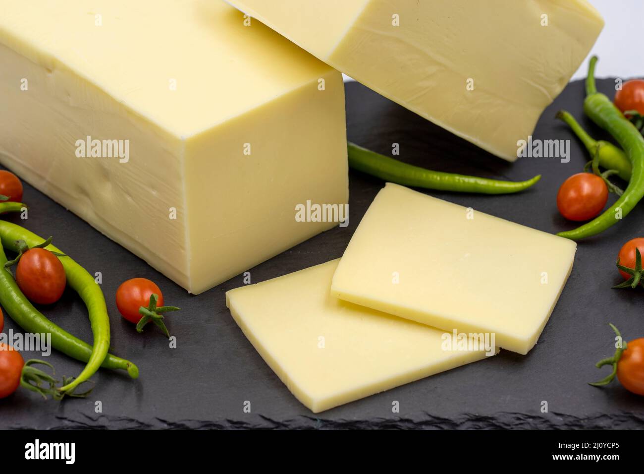 Fromage cheddar ou kashkaval sur fond blanc. Tranches de fromage sur le plateau de service Banque D'Images