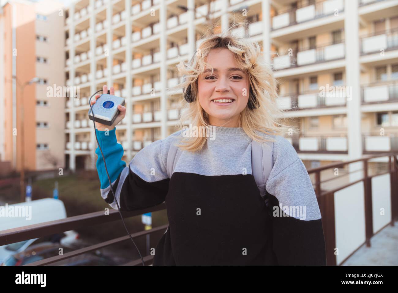 90s vibes. Écouter de la musique à partir de cassettes. Sourire une fille européenne à l'écoute de la musique à l'extérieur. Photo de haute qualité Banque D'Images