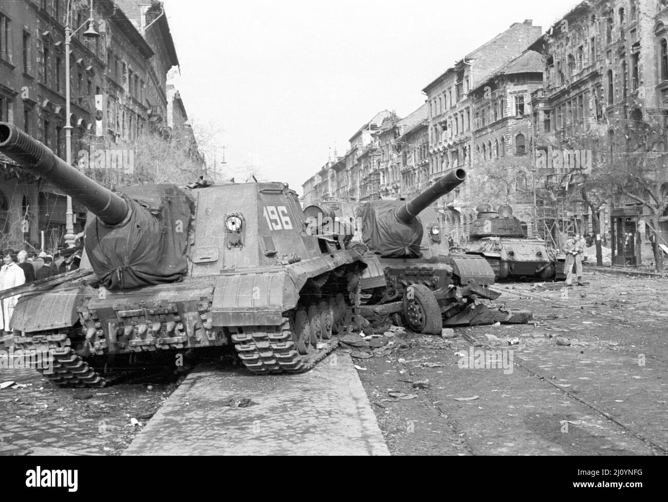 Deux pistolets soviétiques handicapés ISU-152 dans le district de Budapest en 8th avec un char T-34/85 abandonné en arrière-plan. Pendant la révolution hongroise de 1956 Banque D'Images