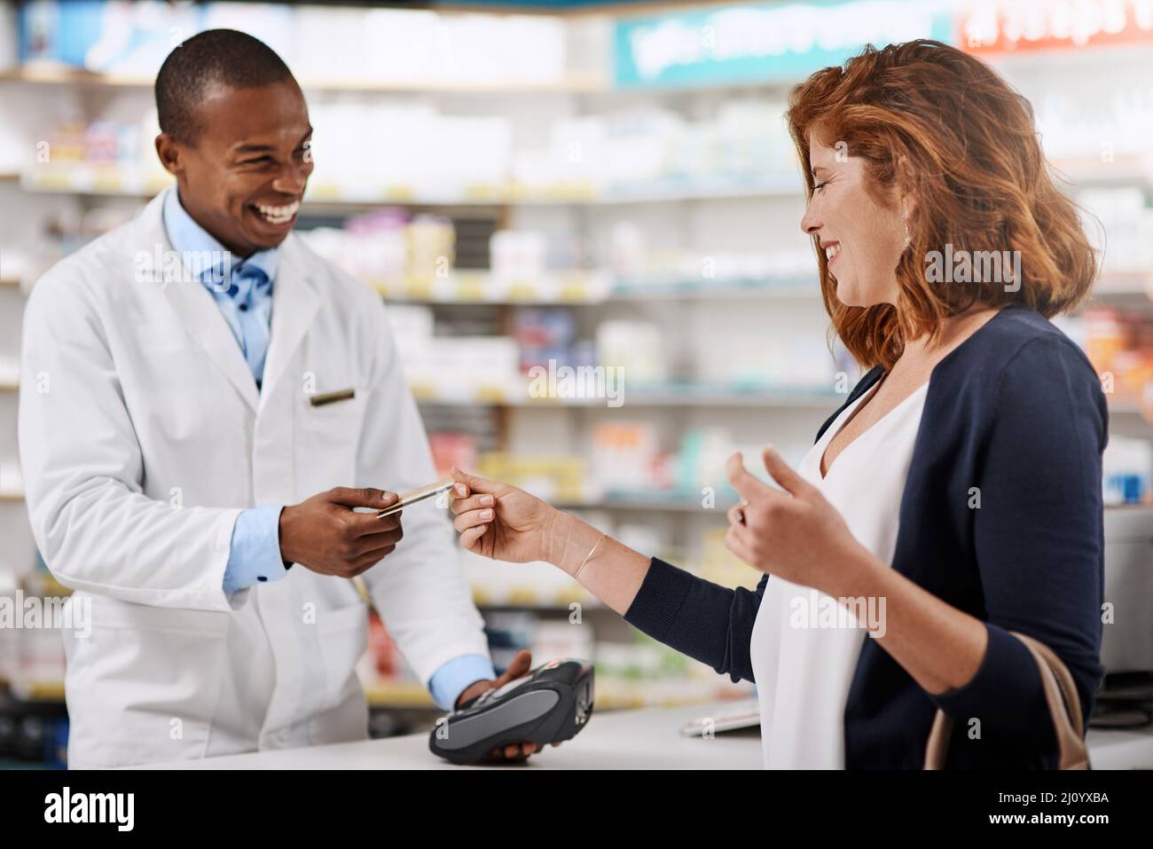 Triez toutes vos factures médicales en toute simplicité. Photo d'un client utilisant une carte de crédit pour payer un achat dans une pharmacie. Banque D'Images