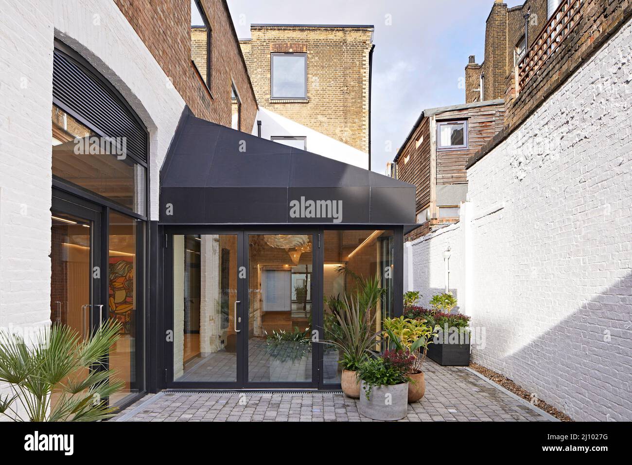 Approche de l'entrée du bâtiment. Symes Mews, Londres, Royaume-Uni. Architecte: PH+ Architectes, 2020. Banque D'Images