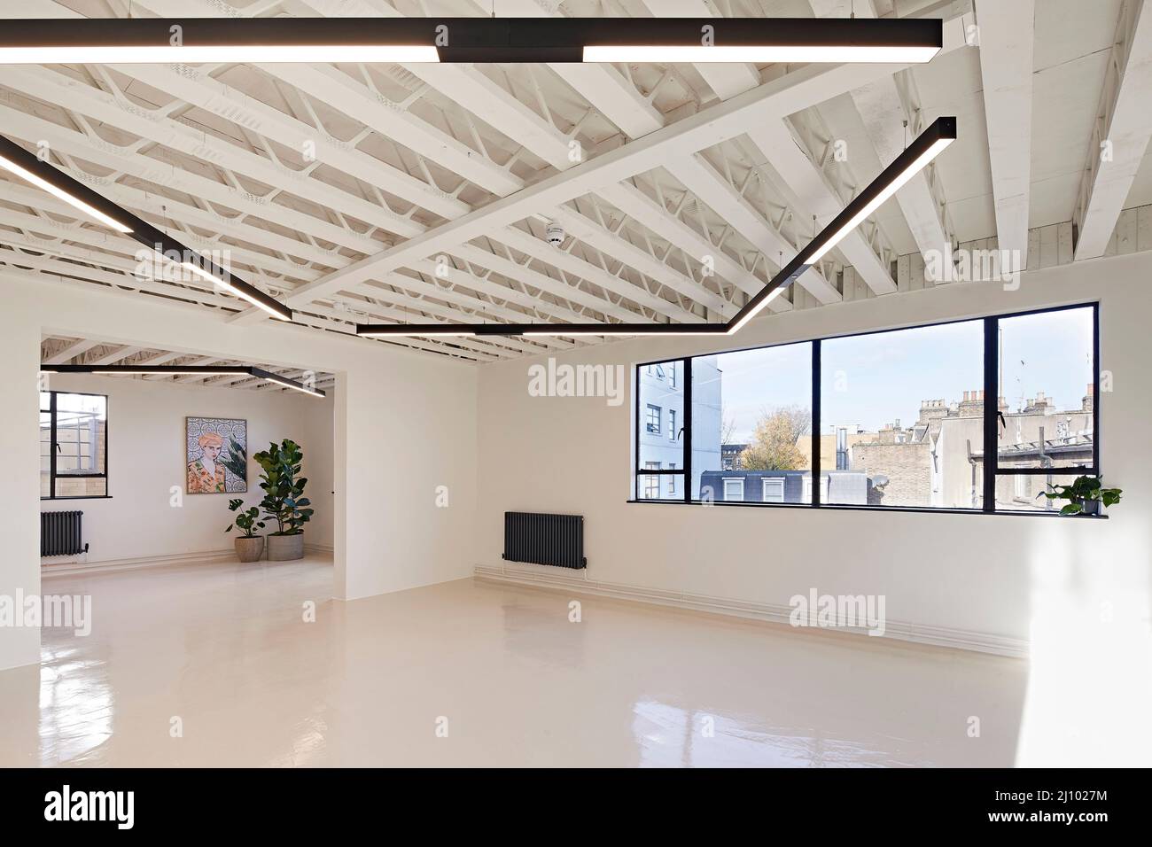 Espaces de travail non meublés avec plafond exposé et fenêtres panoramiques. Symes Mews, Londres, Royaume-Uni. Architecte: PH+ Architectes, 2020. Banque D'Images
