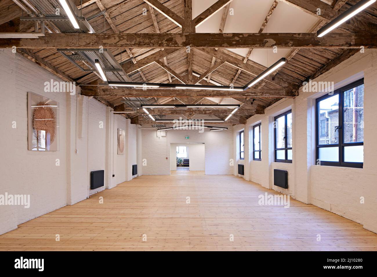 Espace de travail ouvert au dernier étage avec plafond exposé. Symes Mews, Londres, Royaume-Uni. Architecte: PH+ Architectes, 2020. Banque D'Images