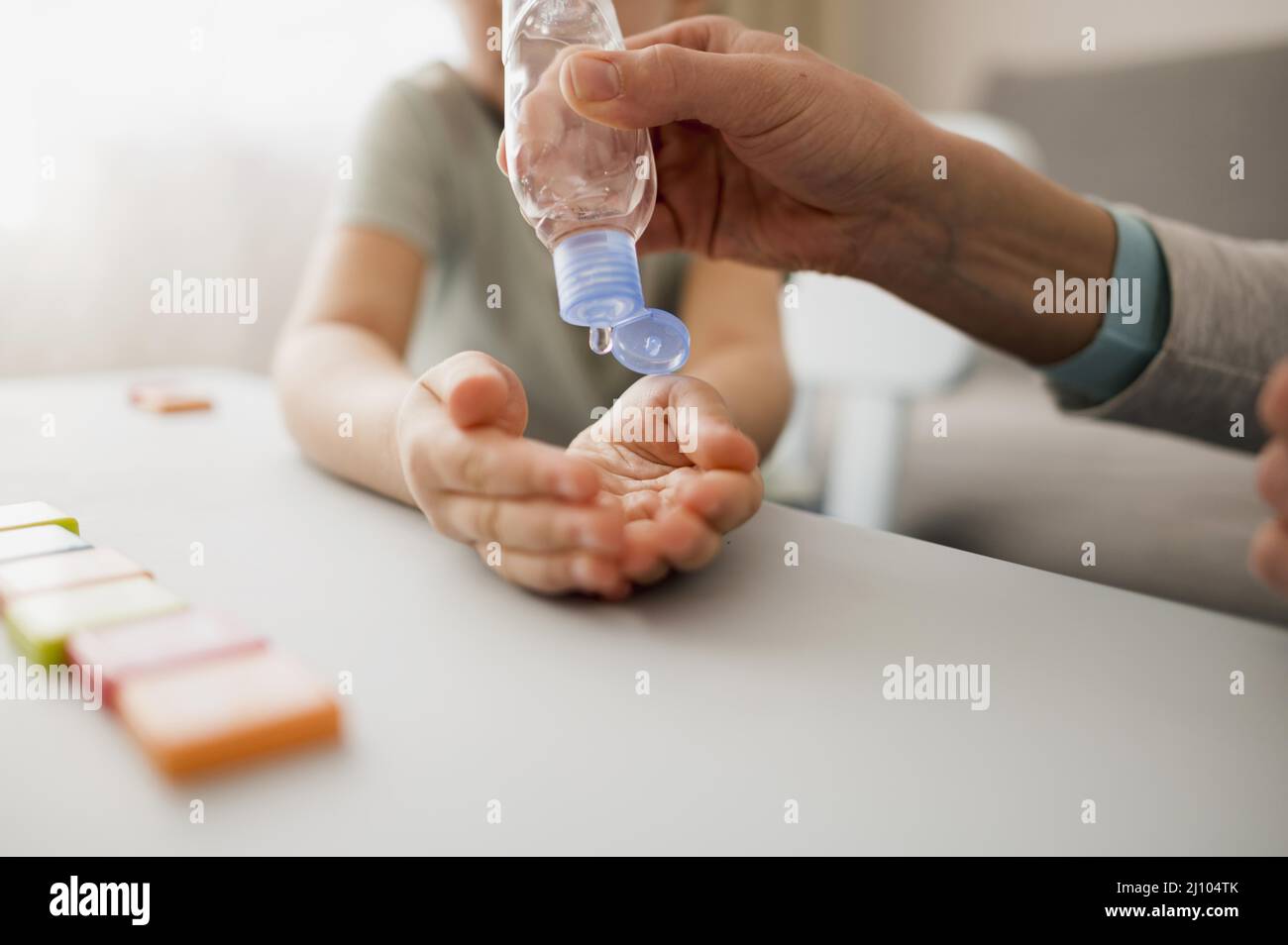 Enfant avec désinfectant pour les mains à la maison avant le cours Banque D'Images